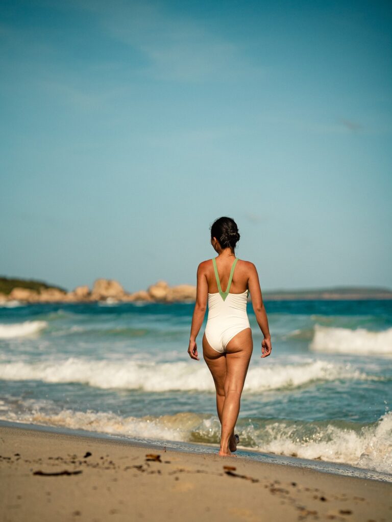 Woman walking into the waves in the Bona one-piece