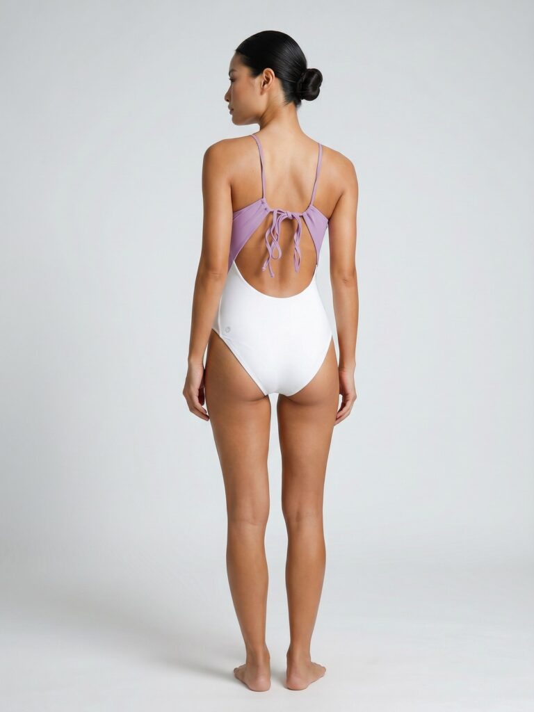 Studio back view of the cream white Pura V-neck tie-back one-piece