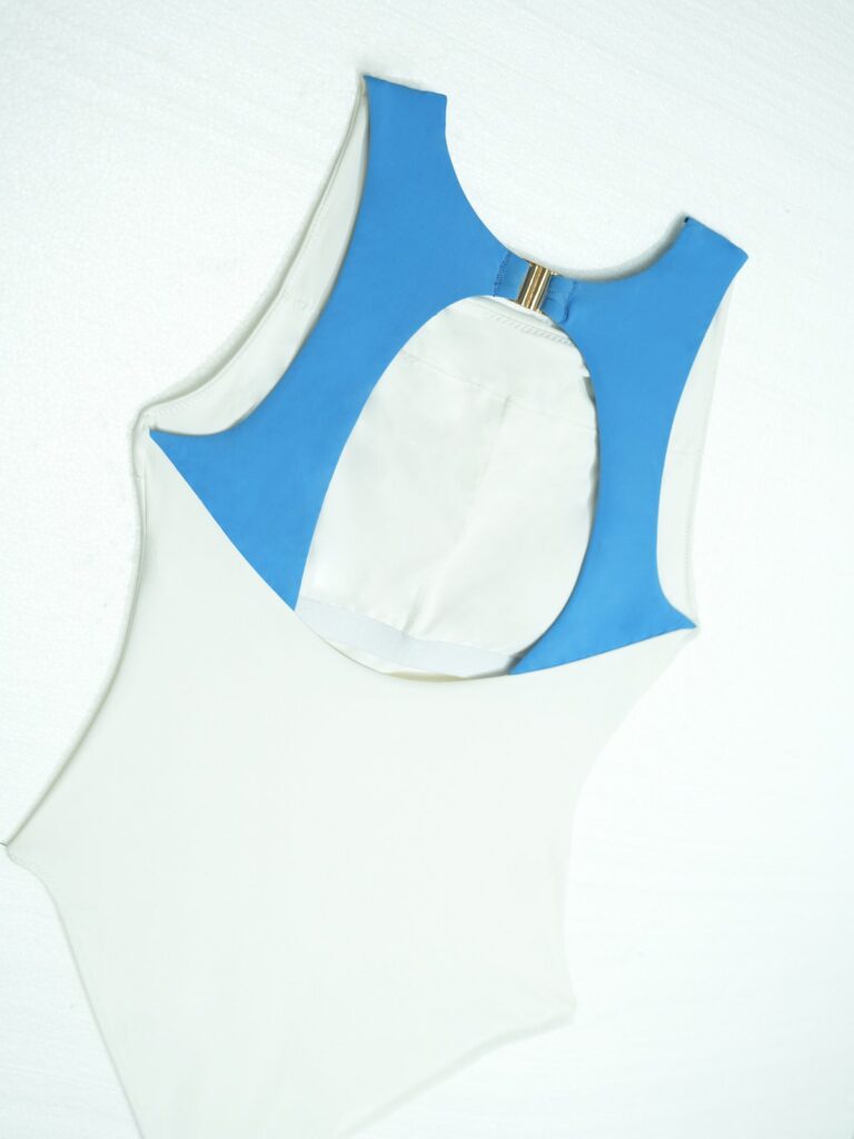 Flat lay of the Pona one-piece back with the sky blue panel and removable cup