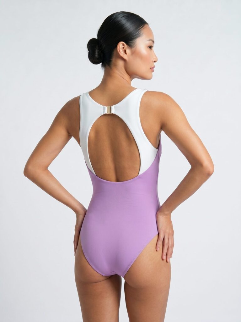 Studio side back view of the pink Pona one-piece showing the cream white back panel
