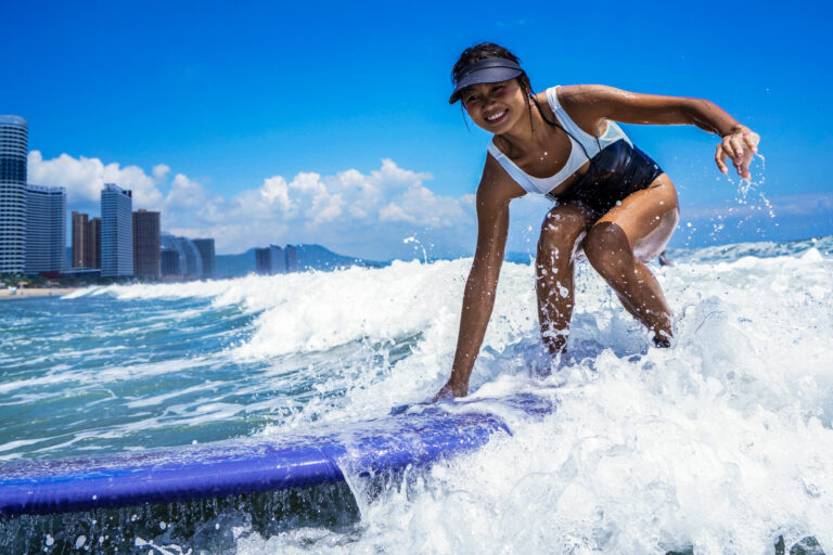 Woman surfing a wave in the black and white Verda one-piece