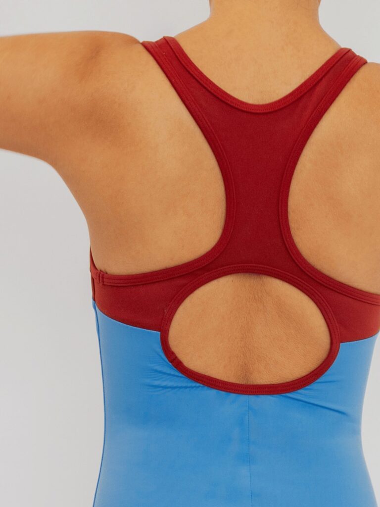 Close-up of the round open back with syrah red panels on the cornflower blue Mira one-piece