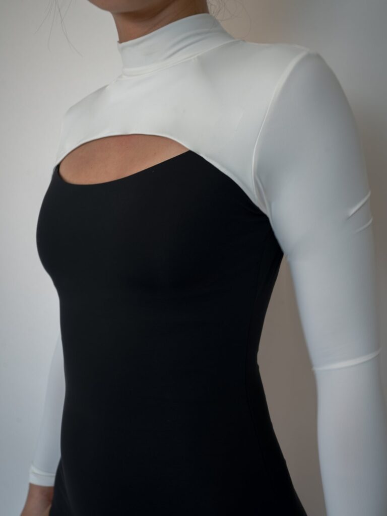 Close-up of the stand collar, white sleeves and front cut-out of the Rosa one-piece
