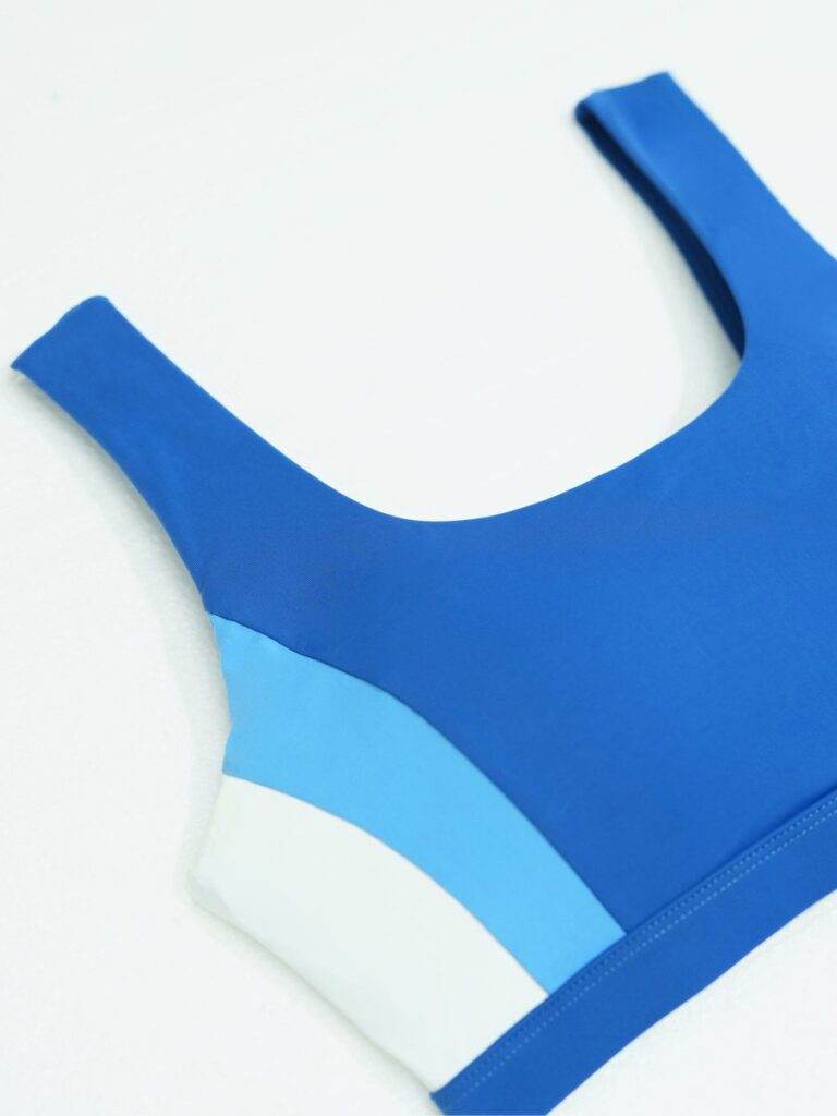 Flat lay detail of the royal blue Zeta top showing the colour-block side panel