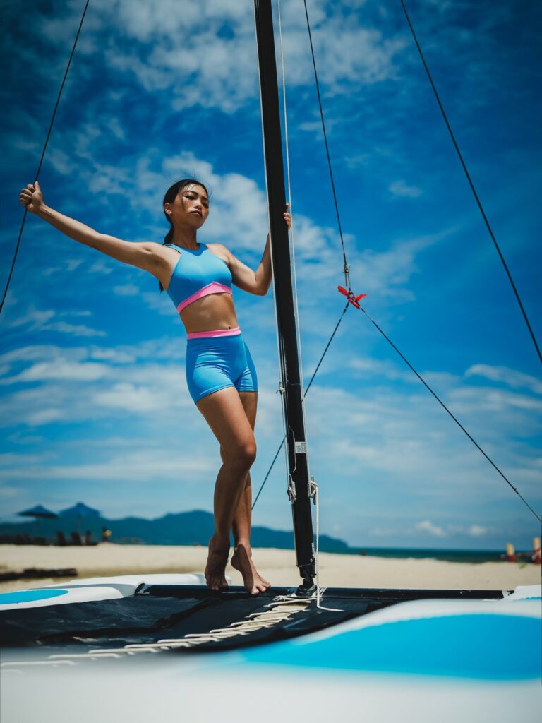 Woman on a catamaran under a blue sky in the azure blue Tenacy two-piece