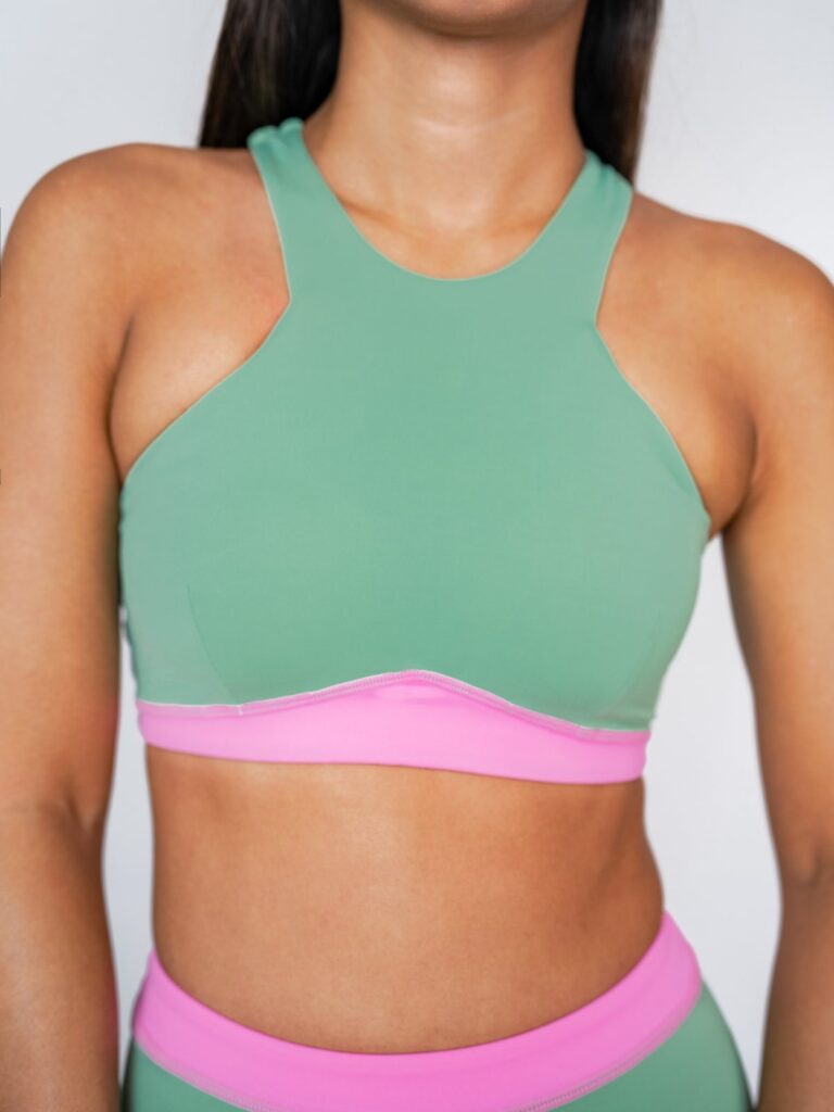 Close-up of the matcha green Tenacy top with its high neck and pink underband