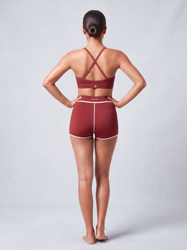 Studio back view of the Cala swim top showing the adjustable cross-back straps, and the high-waist boyshort