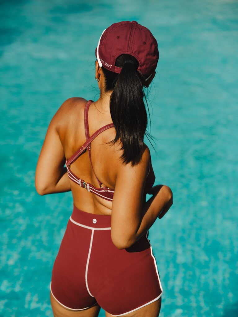 Back view of a woman by a pool in the Cala boyshort showing full seat coverage