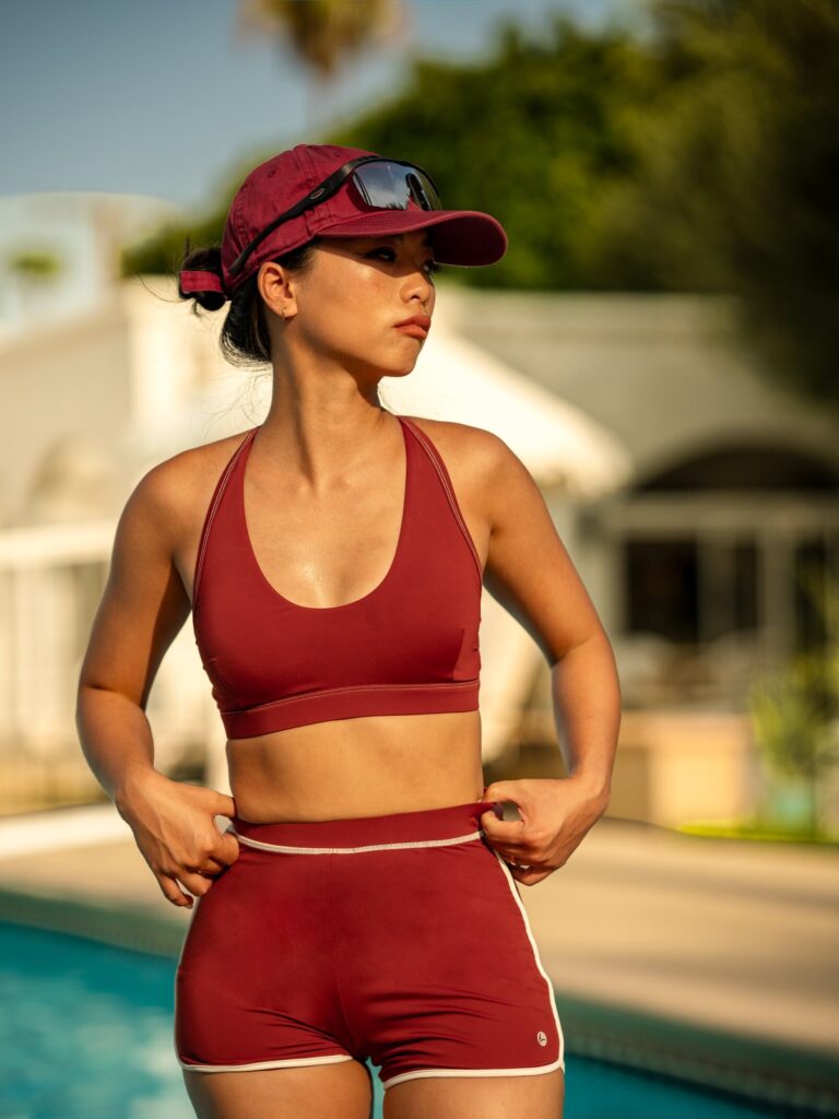 Woman by a pool in the syrah red Cala two-piece