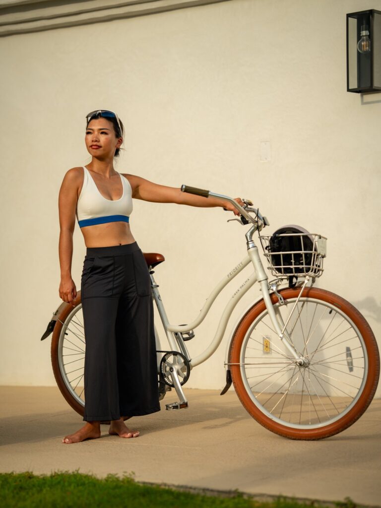 Woman with a bicycle wearing the black wide-leg cropped pants and a sports top