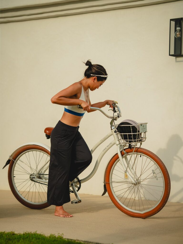 Woman getting onto a bicycle in the black wide-leg cropped pants