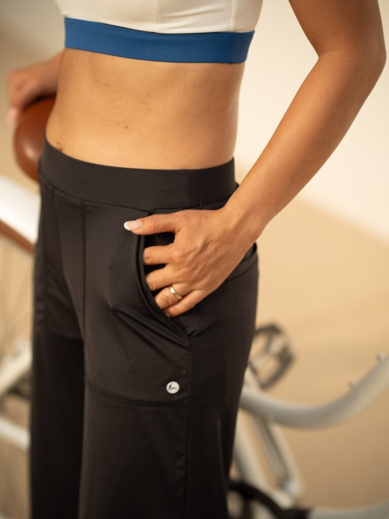 Close-up of a hand in the front pocket of the black wide-leg cropped pants