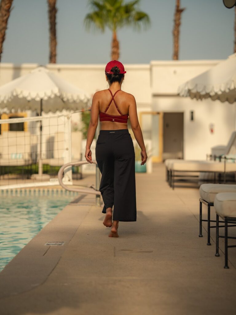 Woman walking along a resort path in the black wide-leg cropped pants