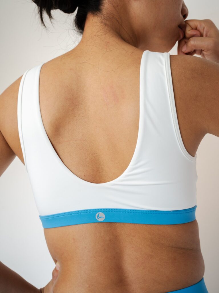 Back close-up of the cream white Siena swim top with a scoop back and blue underband