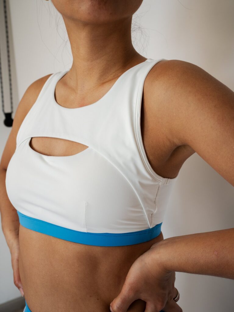 Close-up of the curved front cutout on the cream white Siena swim top with a blue underband