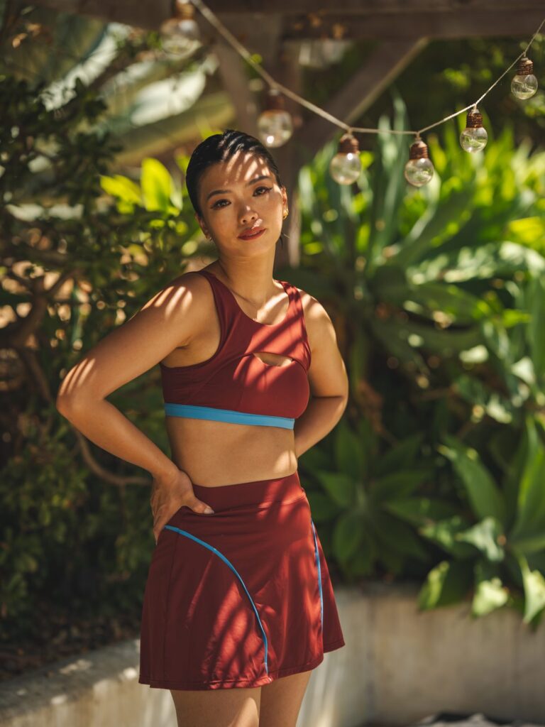 Woman wearing the Siena cutout swim top in syrah red with the Siena high-waist swim skort in syrah red