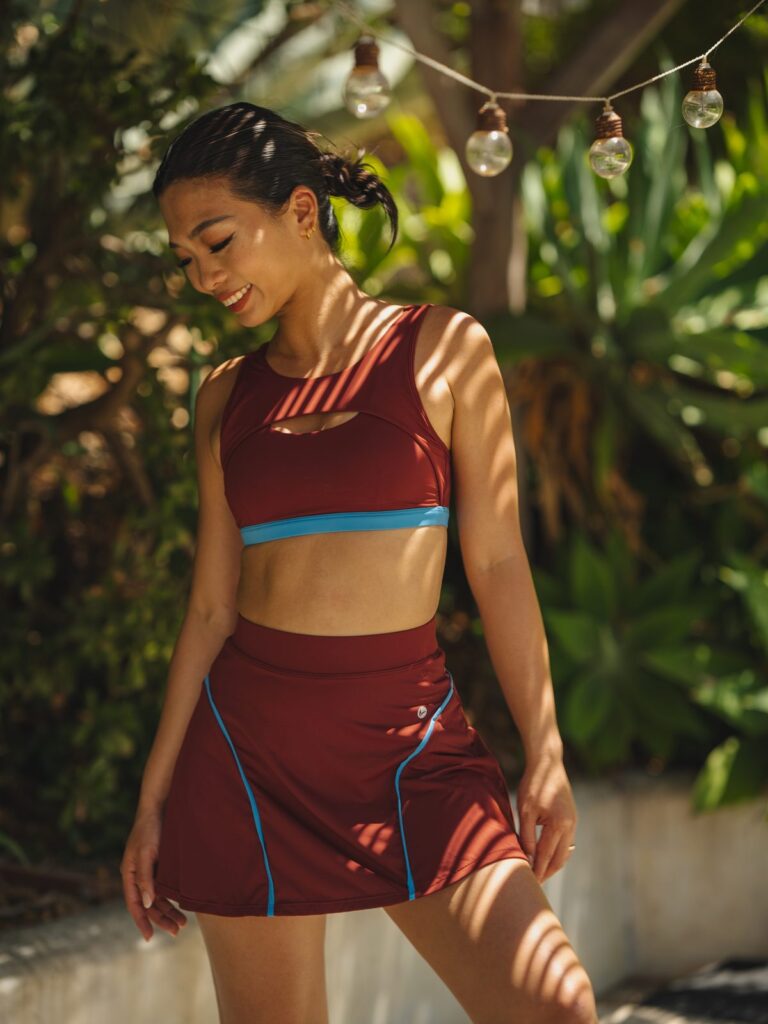 Woman in a garden with string lights wearing the Siena skort and top