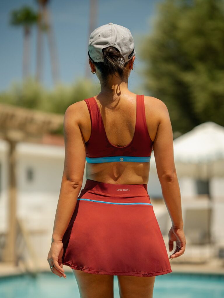 Back view of a woman by a pool showing the scoop back of the Siena swim top