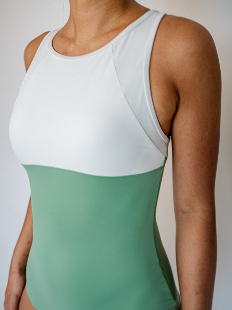 Close-up of the Mira one-piece high neckline in white and matcha green