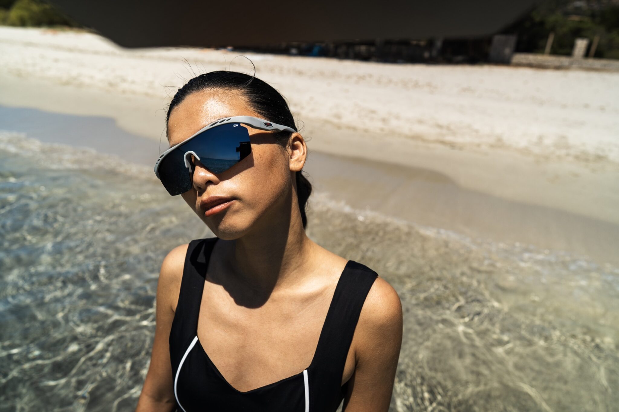 Woman wearing black Leda Sport performance swimwear at the shoreline