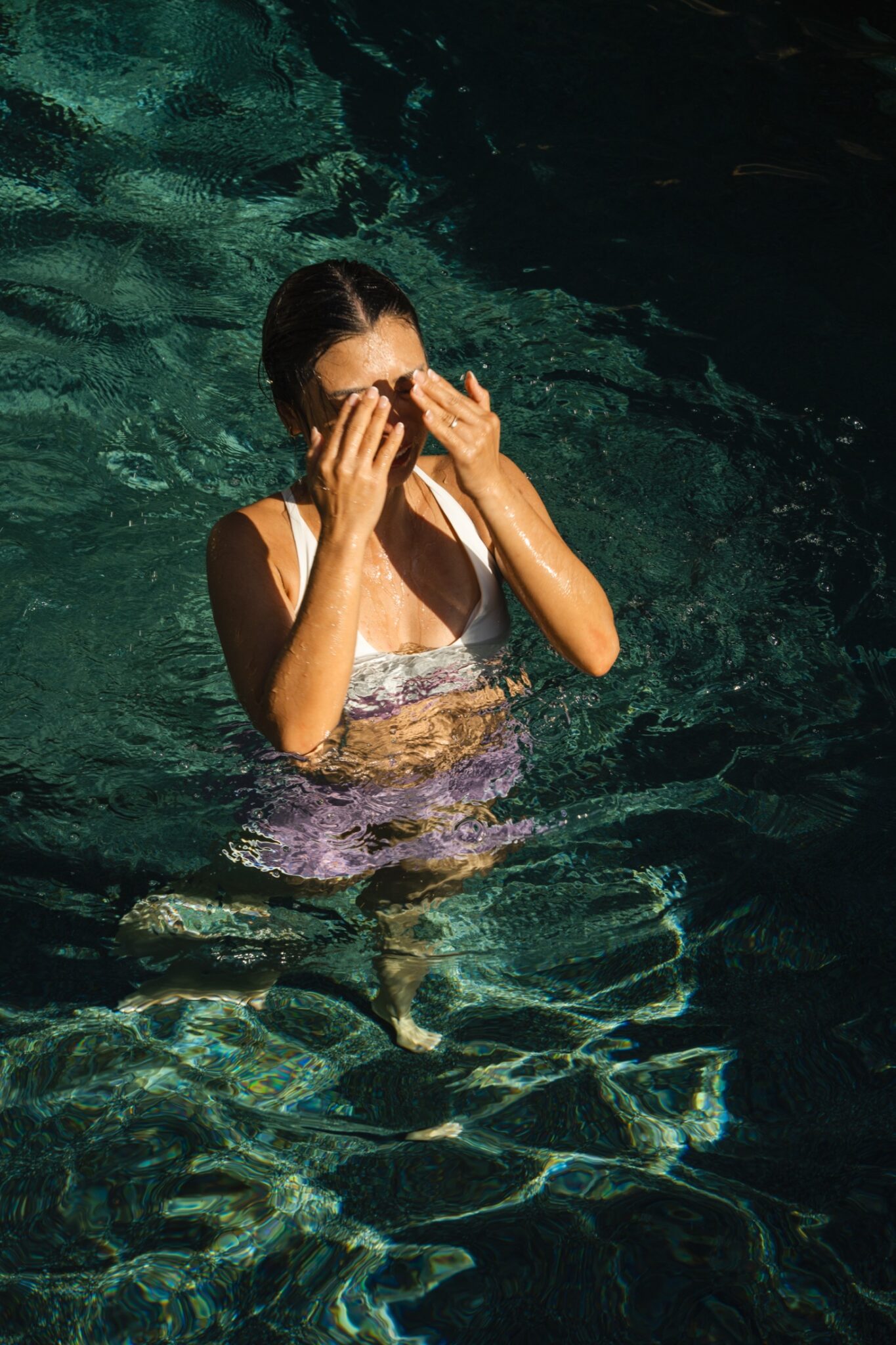 Woman moving freely in a pool in white and lilac Leda Sport swim separates